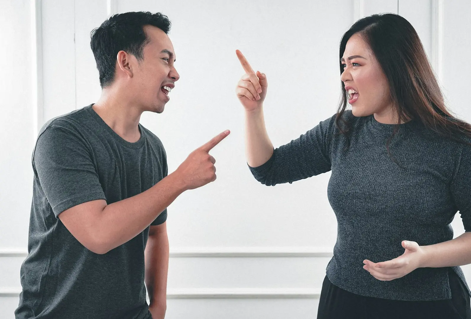 man in gray crew neck long sleeve shirt standing beside woman in black crew neck shirt