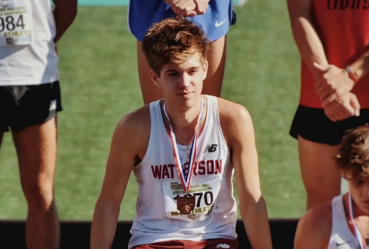 a man sitting on a bench with a medal around his neck